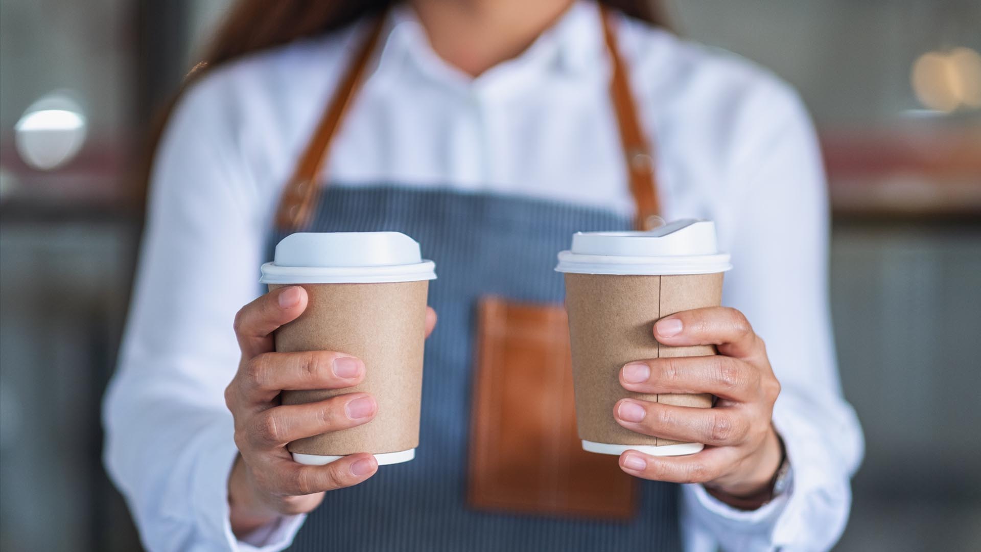 Someone holding a cup of coffee in each hand