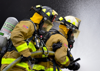 Firefighters and charged hose line