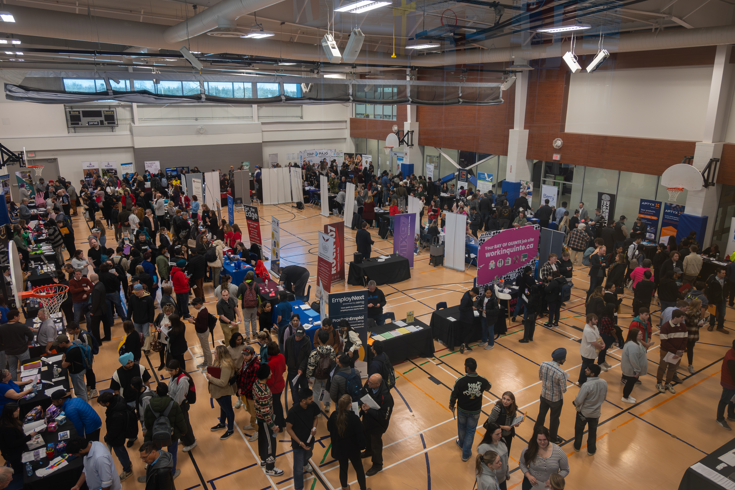 large crowd of people walking around different boths in a building