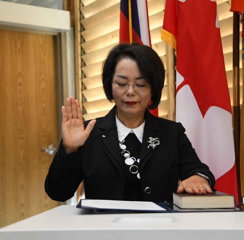 Councillor Margaret Seu hand raised during swear in